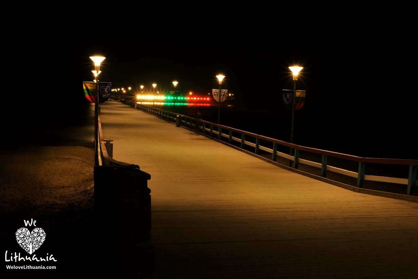 Palangoje ant jūros tilto šviečianti Lietuvos trispalvė.
